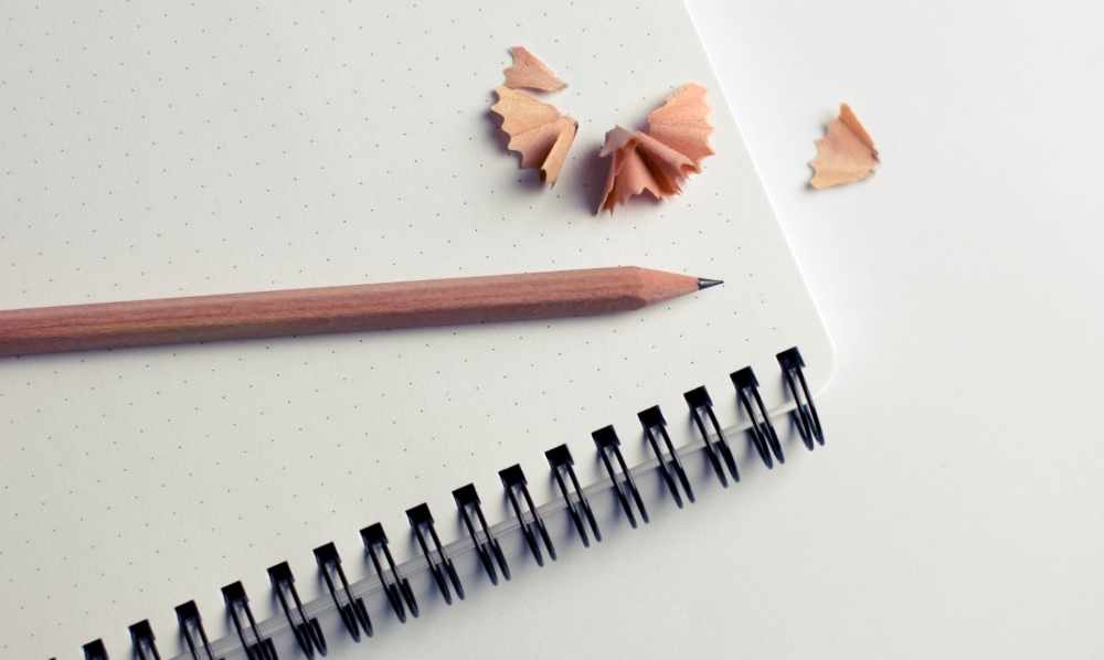 sharpened pencil on top of a notebook