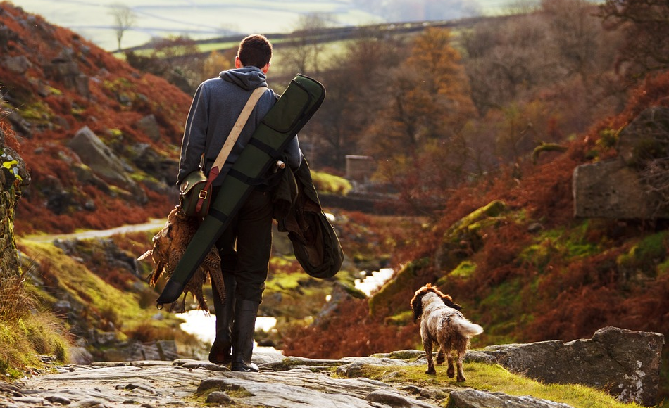 man with hunting tools and a dog